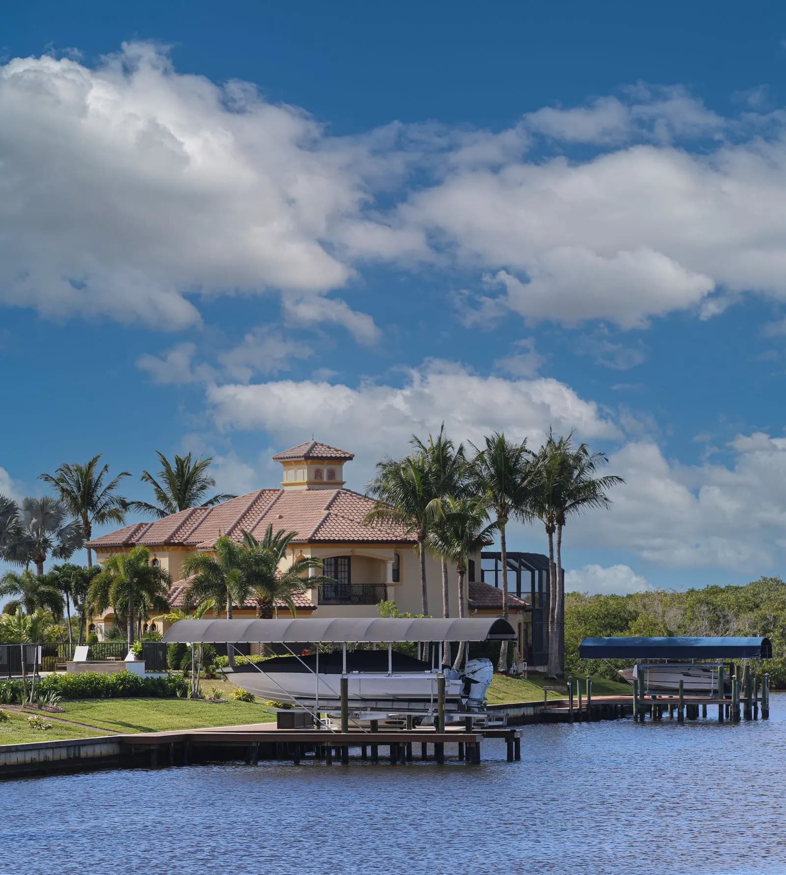Waterfront home with a dock, boat lift and palms on a canal in Cape Coral, Florida