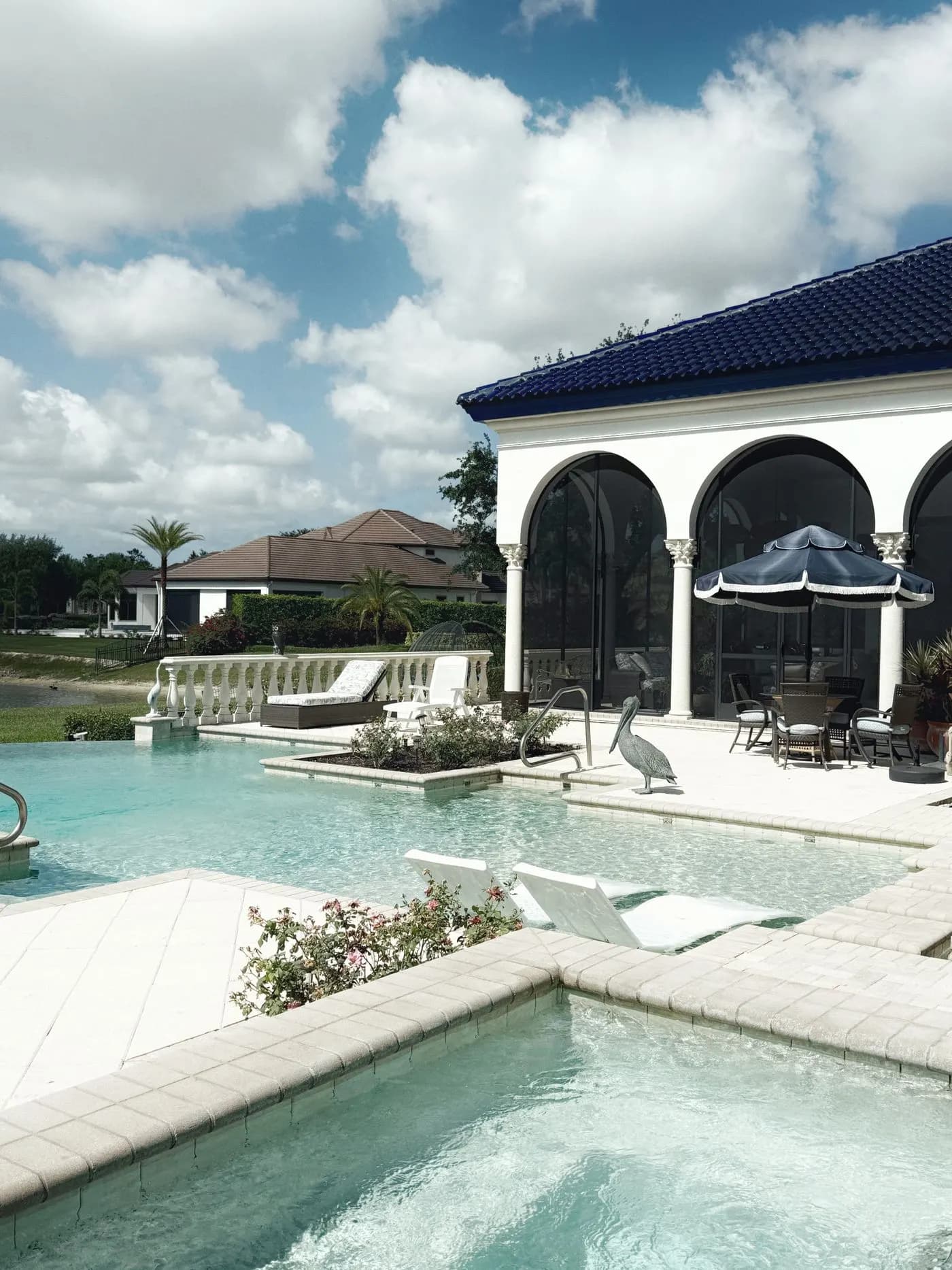 Pool deck and lanai with screened arches and patio furniture