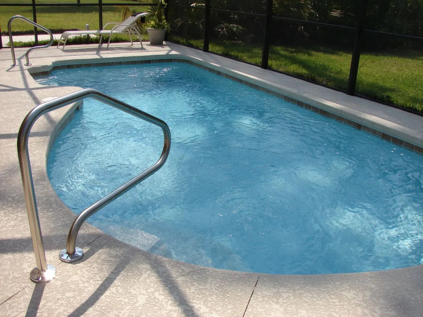 Pool, steps and deck inside a screen enclosure